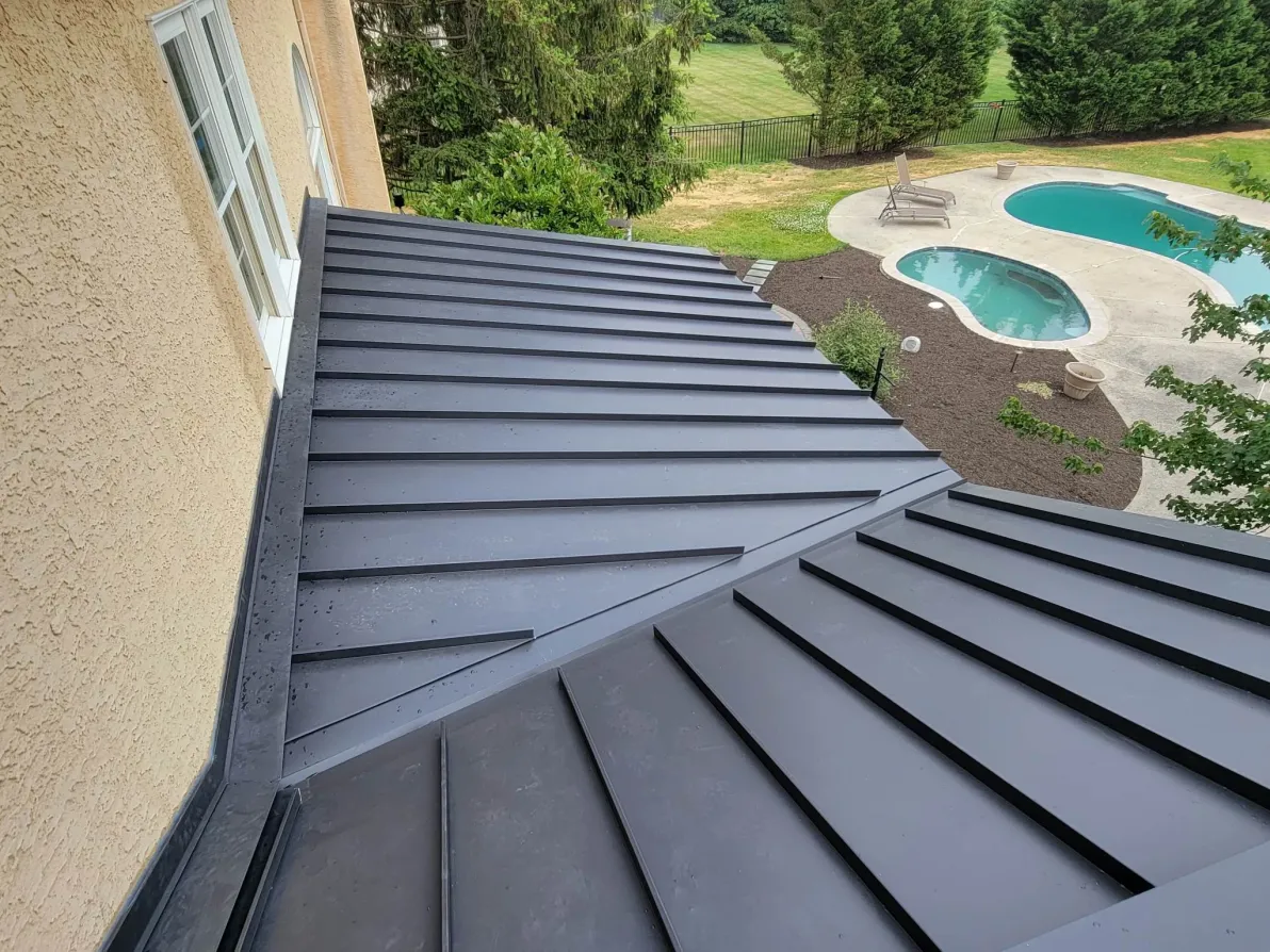 Two-story house with new dark shingle roof and light vinyl siding