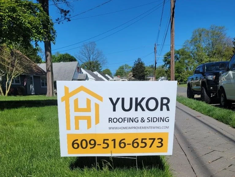 Yukor Construction LLC sign in front of a renovated house