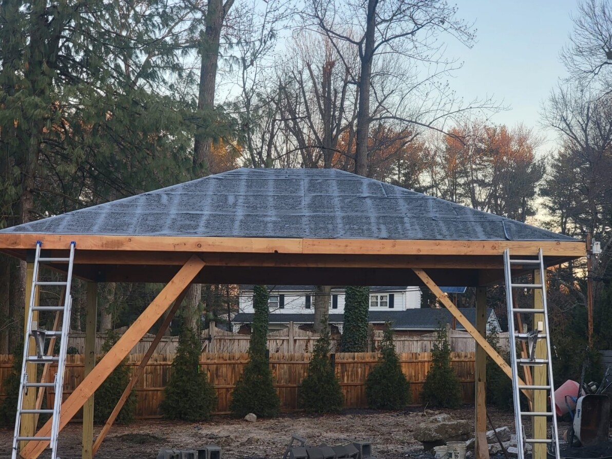 Roof repair in progress with workers laying new shingles
